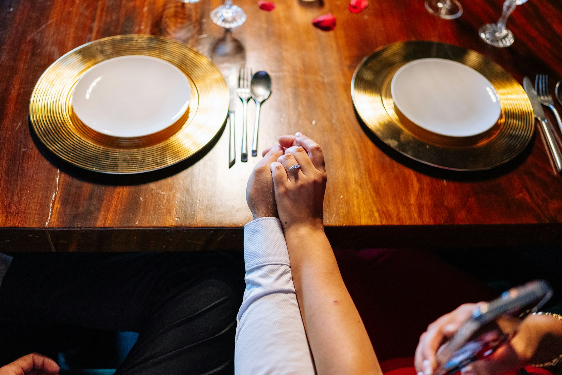 Couple holding hands across a dinner table