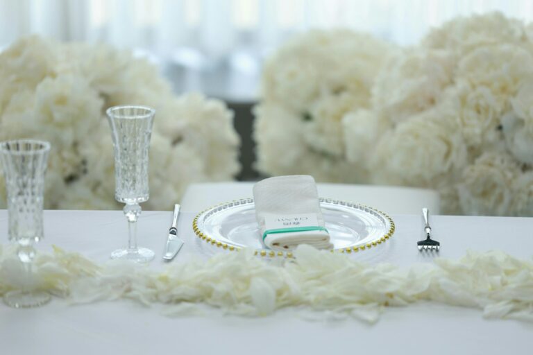 White table setting with white flowers and champagne glasses