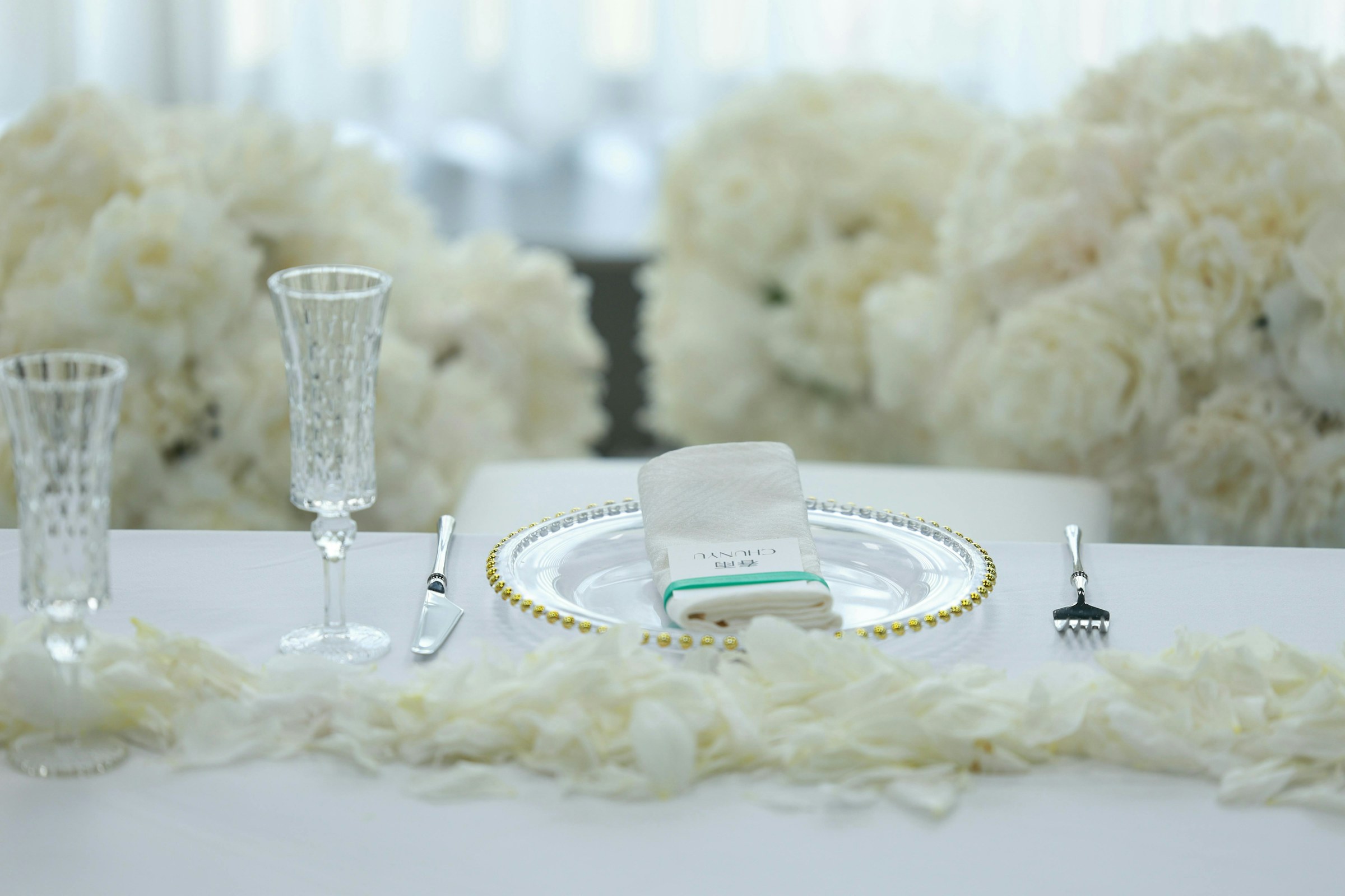 White table setting with white flowers and champagne glasses